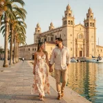 Couple se promenant main dans la main sur le front de mer de Palma de Majorque avec la cathédrale en arrière-plan