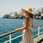 Femme sur le pont d'un bateau de croisière contemplant les îles grecques sous un ciel estival